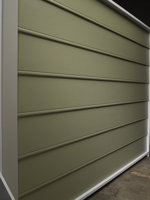 Beaded seam siding A siding sample in a warehouse of beaded seam siding that is army green.